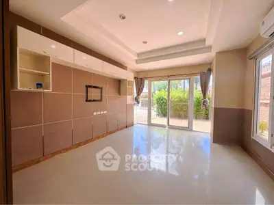 Spacious living room with modern built-in cabinets and large windows