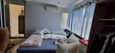 Cozy bedroom with natural light, featuring a comfortable bed and modern air conditioning.