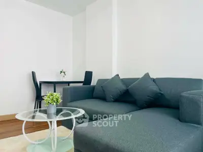 Modern living room with sleek gray sofa and glass coffee table, perfect for stylish urban living.