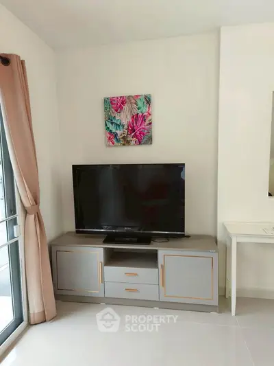 Modern living room with TV and stylish decor in a bright apartment.