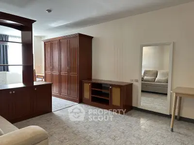 Spacious living room with elegant wooden furniture and large mirror, perfect for modern living.