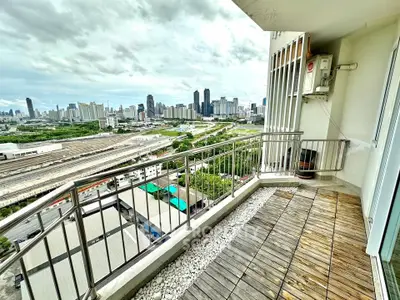 Stunning cityscape view from a modern balcony with wooden flooring and railings.