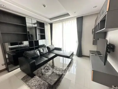 Modern living room with sleek black leather sofa and large mirrored cabinets