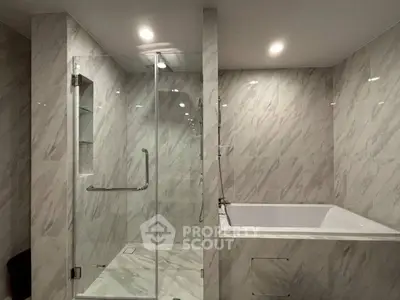 Luxurious marble bathroom with glass shower and soaking tub