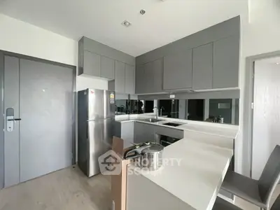 Modern kitchen with sleek cabinetry and stainless steel appliances in a contemporary apartment.