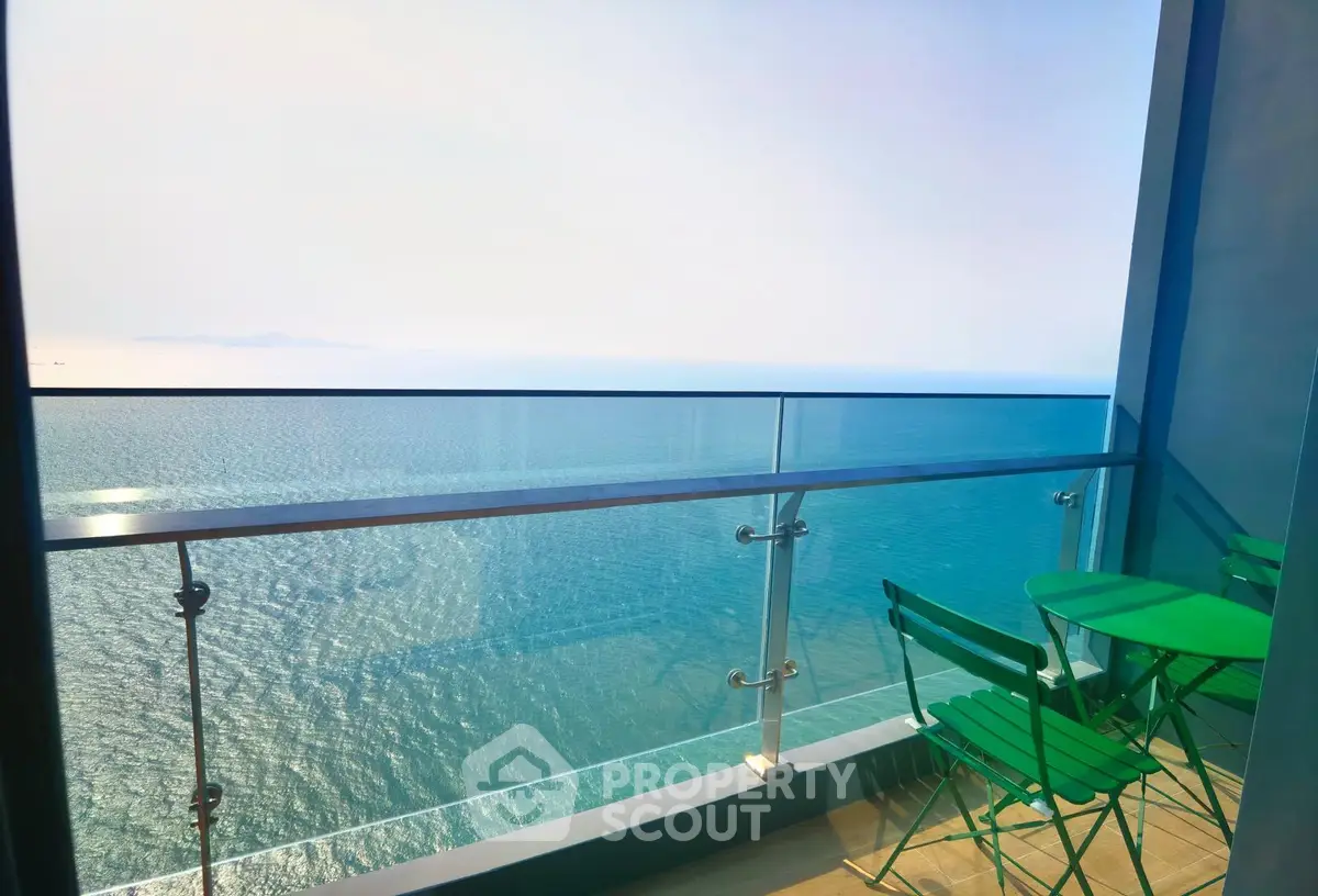 Stunning ocean view from a modern balcony with green furniture, perfect for relaxation.