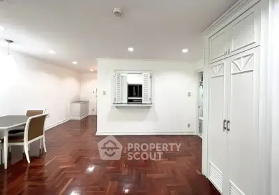 Spacious living room with elegant wooden flooring and built-in storage, perfect for modern living.