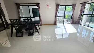 Spacious dining area with large windows and modern furniture, perfect for family gatherings.