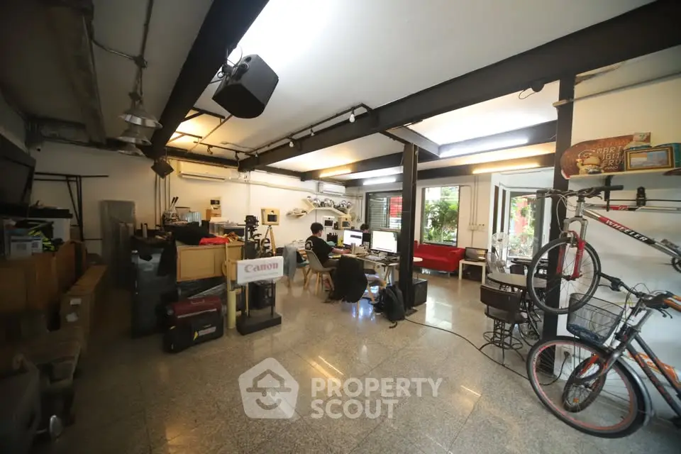 Spacious home office with modern decor and ample natural light, featuring open layout and stylish furnishings.