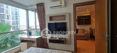 Modern bedroom with large windows and city view, featuring a wall-mounted TV and air conditioning.