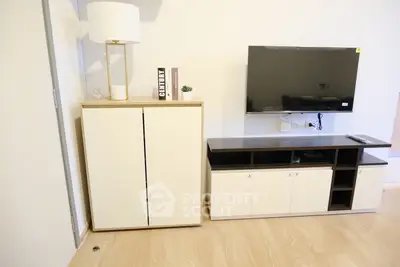 Modern living room with sleek TV stand and stylish cabinet on wooden floor.