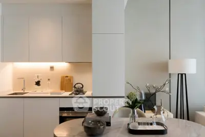 Modern kitchen with sleek cabinetry and elegant dining setup in a stylish apartment.