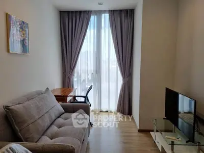 Cozy living room with modern sofa, TV, and elegant curtains in a bright apartment.