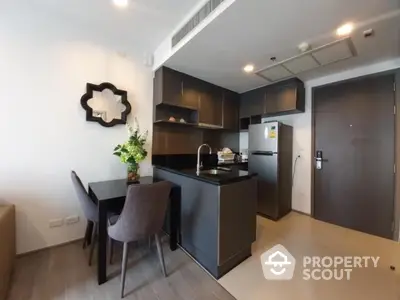 Modern kitchen with sleek black cabinets and dining area in stylish apartment