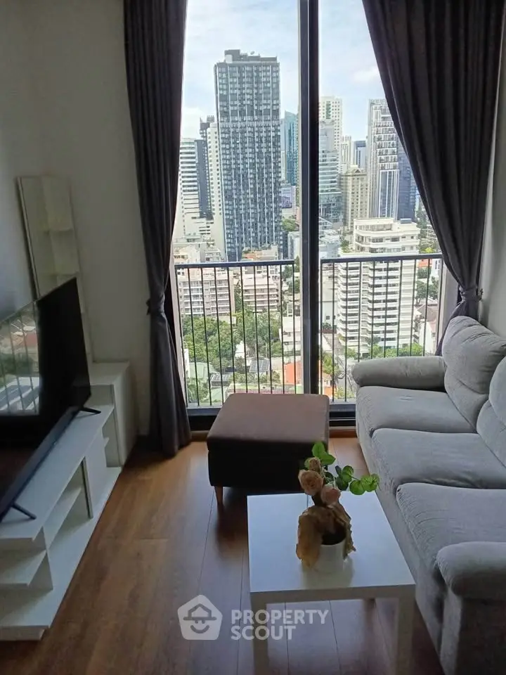 Modern living room with city view, featuring cozy sofa and large window for natural light.