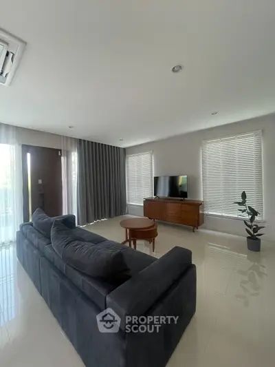 Spacious modern living room with sleek sofa and large windows