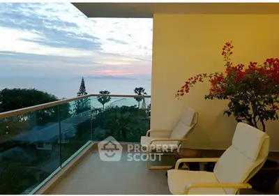 Stunning balcony with ocean view and cozy seating, perfect for relaxation.