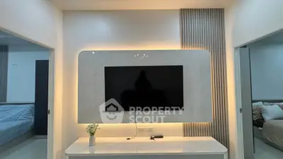 Modern living room with sleek TV setup and ambient lighting, showcasing contemporary interior design.
