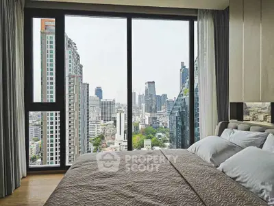 Luxurious bedroom with stunning city skyline view from large windows, featuring modern decor and cozy bedding.