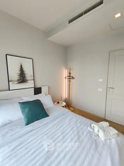 Modern bedroom with stylish decor and cozy ambiance, featuring a comfortable bed and elegant artwork.