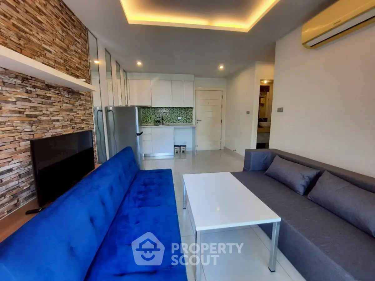 Modern living room with stylish stone accent wall and sleek furniture in a contemporary apartment.