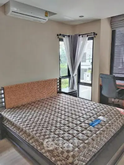 Cozy bedroom with large window and modern furnishings in a stylish apartment.