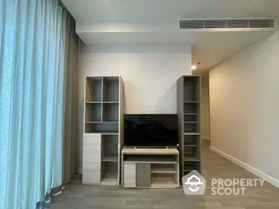 Modern living room with sleek TV stand and shelving units, featuring elegant curtains and minimalist design.