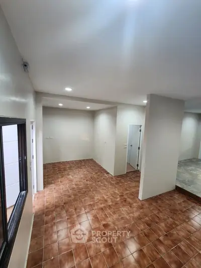 Spacious interior with tiled flooring and modern lighting, ideal for versatile living arrangements.