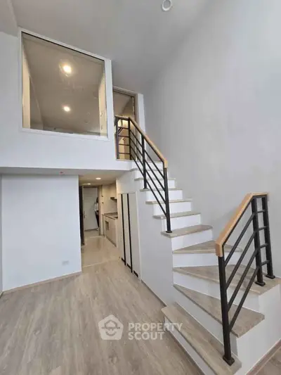 Modern duplex interior with sleek staircase and open layout