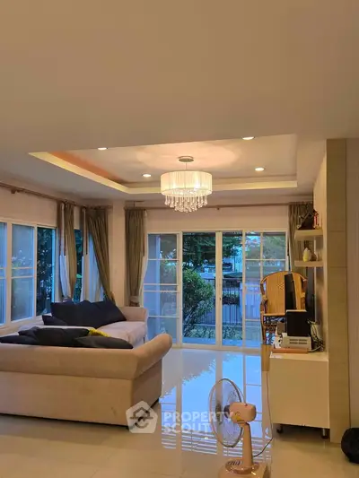 Spacious living room with elegant chandelier and large windows