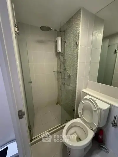 Modern bathroom with glass shower enclosure and sleek fixtures.