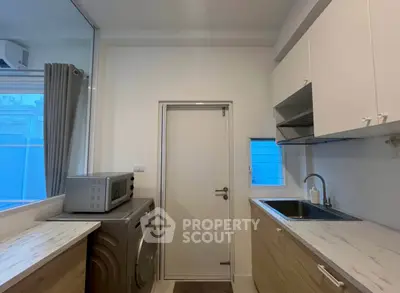 Modern kitchen with washing machine and sleek cabinetry