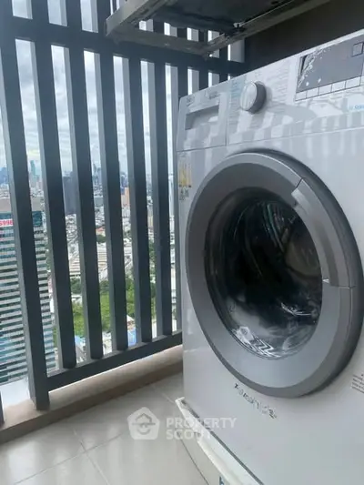 Modern washing machine on high-rise balcony with cityscape view