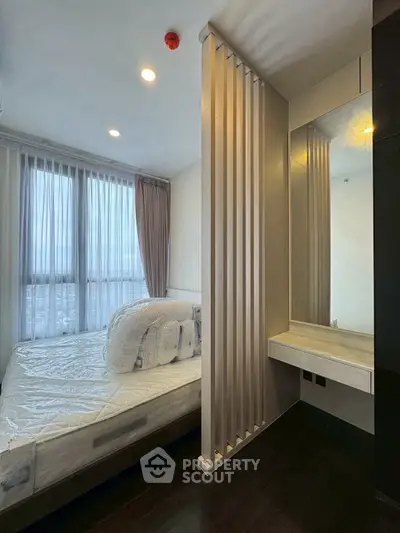 Modern bedroom with large window and stylish partition in high-rise apartment