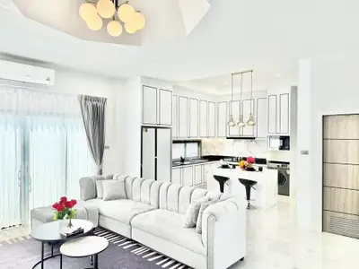 Luxurious open-plan living room and kitchen with modern decor and natural light.