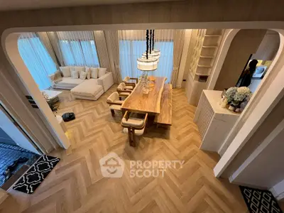Luxurious open-plan living and dining area with elegant wooden flooring and modern furnishings.