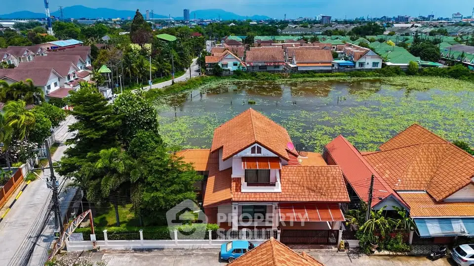 Charming suburban home with red-tiled roof and scenic pond view