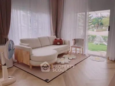 Charming living room with cozy sofa and garden view, perfect for relaxation.