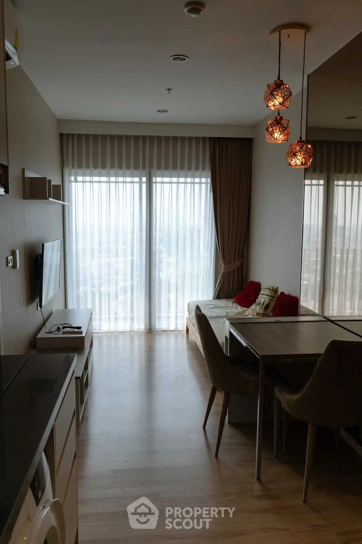 Modern living room with stylish lighting and large windows in a cozy apartment.