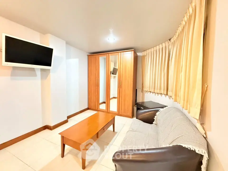 Cozy living room with modern furniture and wall-mounted TV, perfect for relaxation.