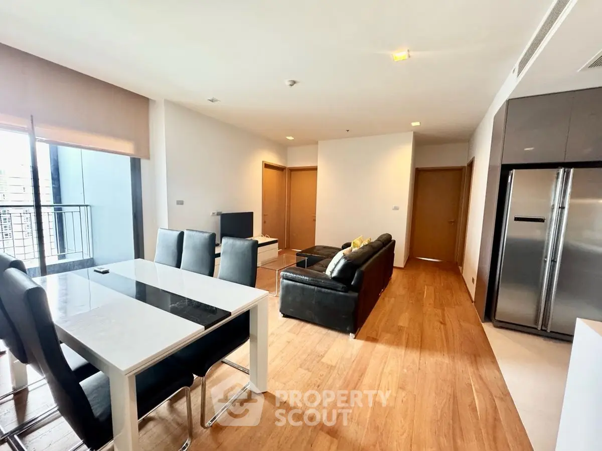 Spacious modern living room with sleek furniture and open layout in a high-rise apartment.