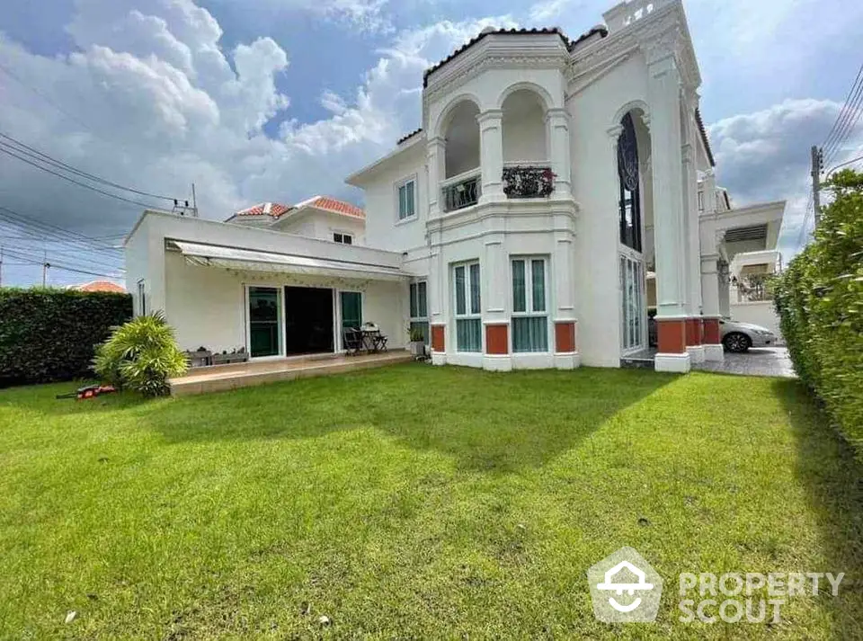 Elegant two-story villa with lush green lawn and classic architectural design