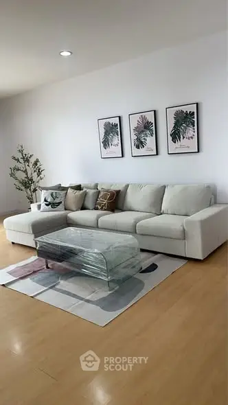 Stylish living room with modern sectional sofa, glass coffee table, and elegant decor.