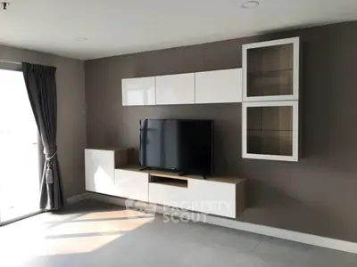 Modern living room with sleek TV unit and natural light