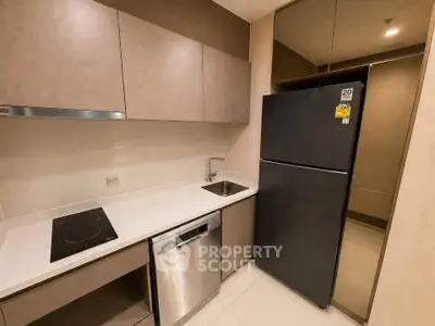 Modern kitchen with sleek cabinetry, stainless steel appliances, and induction cooktop in a compact layout.
