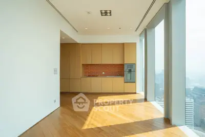 Spacious modern kitchen with floor-to-ceiling windows and wooden flooring in a high-rise apartment.