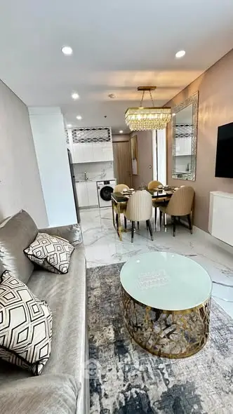 Luxurious modern living room with elegant decor and open kitchen layout, featuring chic furniture and stylish lighting.