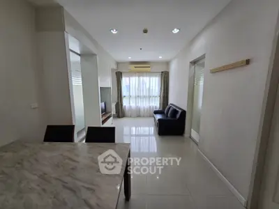 Spacious living room with modern decor and natural light in a stylish apartment.