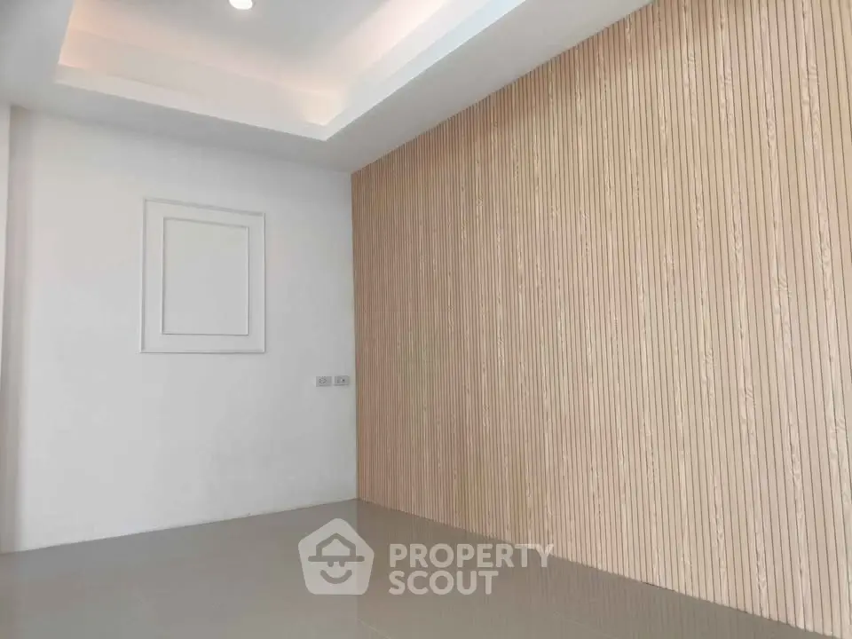Modern minimalist interior with textured accent wall and recessed lighting