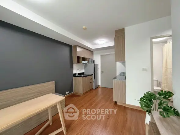 Modern studio apartment with sleek kitchen and wooden flooring